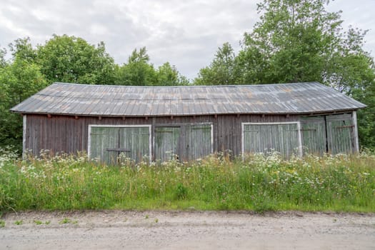 Old Worn Barn by dirt road in Sweden.