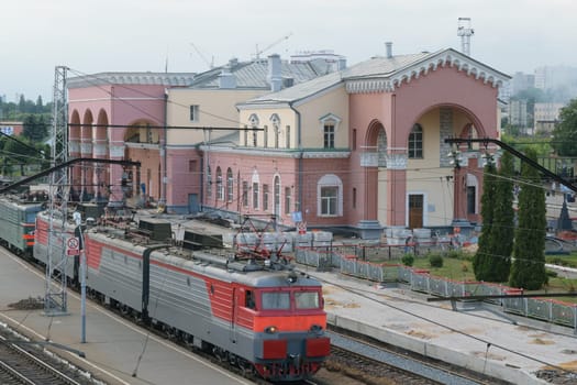 The electric train arrives to the railway station. Repair of roads and the platform at the train station.