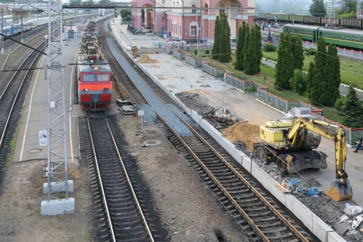 The electric train arrives to the railway station. Repair of roads and the platform at the train station.