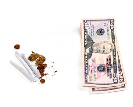 A stack of three 50 dollar US bills is shown beside a cluster of marijuana pot buds and three joints, over white.