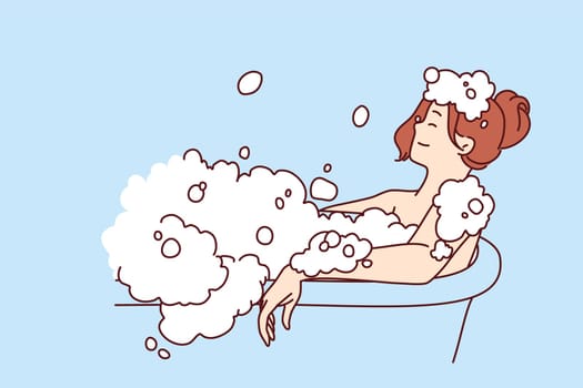 Carefree woman relaxes lying in bath with foam and warm water after hard day at work or long walk. Concept of water spa treatments for relaxation and wellness or for skin and body care