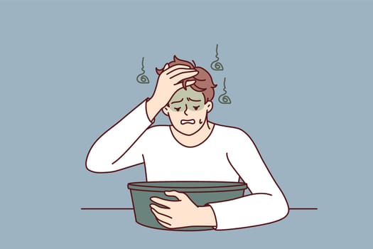 Young man feels nausea sitting near basin experiencing problem after being poisoned or suffering from hangover. Guy with symptoms of nausea and vomiting after alcohol party and unhealthy lifestyle