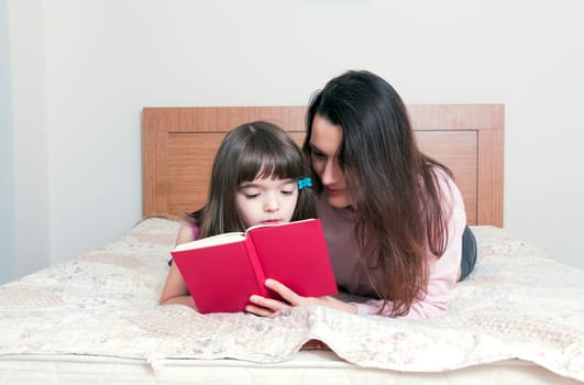 Mom with the daughter reading together