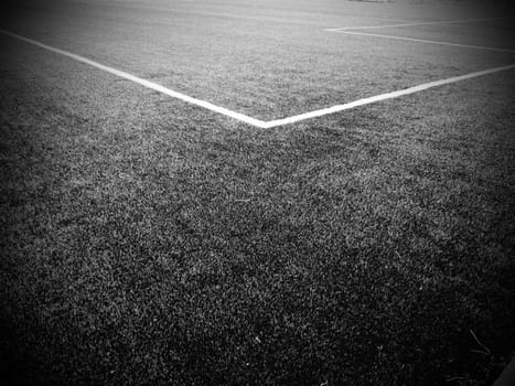 The marking of the football field. White lines no more than 12 cm or 5 inches wide. Football field area. Black and white monochrome photography.