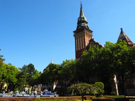 Subotica, Serbia September 12, 2021. Blue fountain in the square next to the Town Hall. Blue ceramic parts with monograms. A working fountain with splashing water. Summer sunny day by the blue water