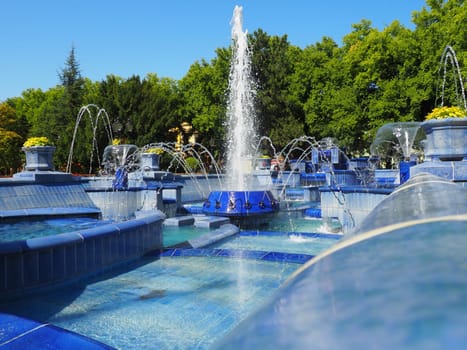 Subotica, Serbia September 12, 2021. Blue fountain in the square next to the Town Hall. Blue ceramic parts with monograms. A working fountain with splashing water. Summer sunny day by the blue water.