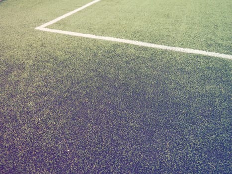 The marking of the football field on the green grass. White lines no more than 12 cm or 5 inches wide. Football field area. Side lines, goal lines. Sun glare. Color and light gradient.