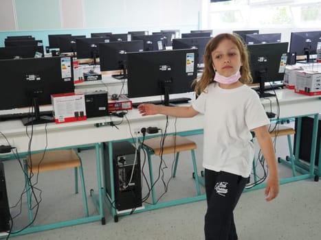 Sremska Mitrovica, Serbia, May 15, 2021 Group of computer neatly placed in a computer lab. Computers, monitors, wires in the modern classroom of the new school. School desks for pupils and students.