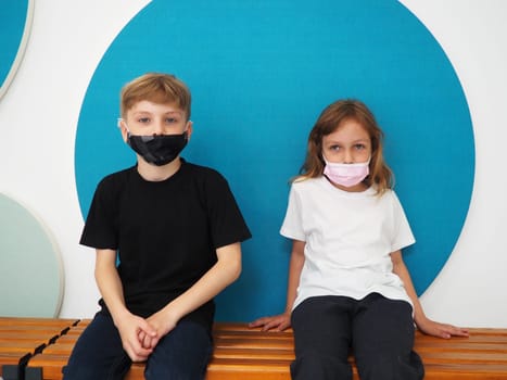School children wearing face mask during corona virus and flu outbreak. Boy and girl going back to school after covid-19 quarantine and lockdown. Group of kids in masks for coronavirus prevention