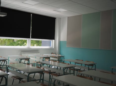 Lecture room with empty seats. Business seminar education. Modern new school. White furniture. Large windows with blackout curtains or blinds. Empty school classroom. Furniture and school equipment.