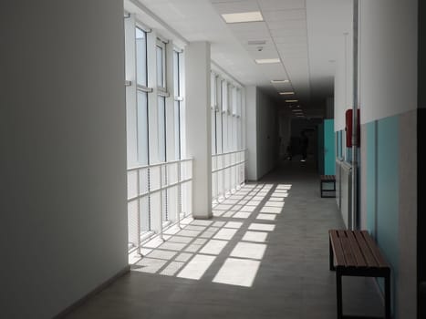 Sremska Mitrovica, Serbia, May 15, 2021. school corridor in a new modern school. White interior of the foyer. High ceilings, large plastic white windows. The sun's rays fall into the room