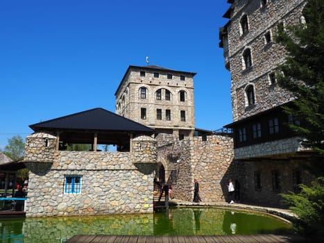 Stanisici, Bijelina, Republika Srpska, Bosnia and Herzegovina April 25 2021 Ethno village, tourism and attractions. Stone and wooden buildings of the hotel. People visit restaurant, traditional houses