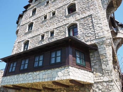 Stanisici, Bijelina, Republika Srpska, Bosnia and Herzegovina April 25 2021 Ethno village, tourism and attractions. Stone and wooden buildings of the hotel. People visit restaurant, traditional houses