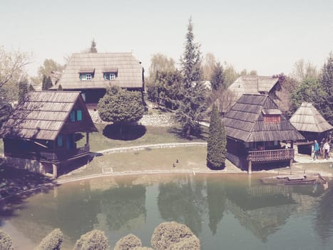 Stanisici, Bijelina, Bosnia and Herzegovina. April 25, 2021 Ethno-village, traditional village houses made of logs, Bosnian style of construction in the highlands. Lake with water. Wooden architecture