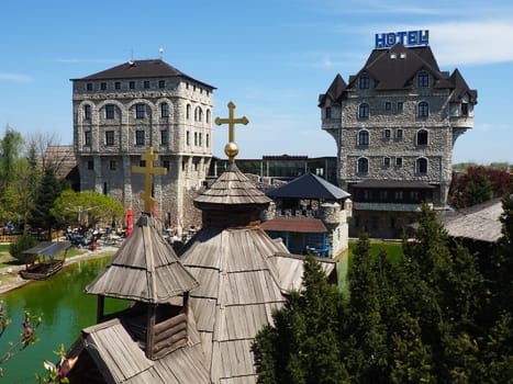 Stanisici, Bijelina, Republika Srpska, Bosnia and Herzegovina April 25 2021 Ethno village, tourism and attractions. Stone and wooden buildings of the hotel. People visit restaurant, traditional houses