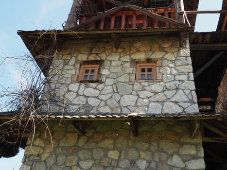 Stanisici, Bijelina, Republika Srpska, Bosnia and Herzegovina April 25 2021 Ethno village, tourism and attractions. Stone and wooden buildings of the hotel. People visit restaurant, traditional houses