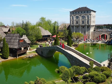 Stanisici, Bijelina, Republika Srpska, Bosnia and Herzegovina April 25 2021 Ethno village, tourism and attractions. Stone and wooden buildings of the hotel. People visit restaurant, traditional houses