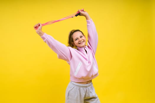 Adorable female child with skipping rope jumping in a studio