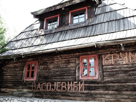 Stanisici, Bijelina, Bosnia and Herzegovina, 25 April 2021. Log village farmhouse. 19th century Bosnian mountain traditional dwelling. Restored ethno building, implements of agricultural labor