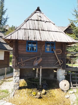 Stanisici, Bijelina, Bosnia and Herzegovina, 25 April 2021. Log village farmhouse. 19th century Bosnian mountain traditional dwelling. Restored ethno building, implements of agricultural labor.
