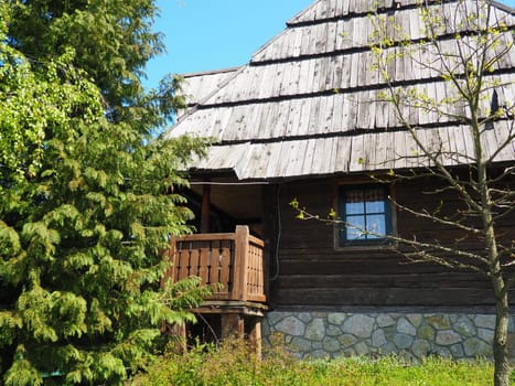 Log village farmhouse. 19th century Bosnian mountain traditional dwelling. Restored ethno building, implements of agricultural labor