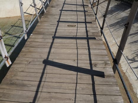 Suspended wooden bridge. Stanisici, Bijelina, Bosnia and Herzegovina. A bridge made of planks and railings, which can be carried by 4 people