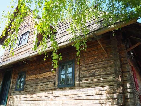Log village farmhouse. 19th century Bosnian mountain traditional dwelling. Restored ethno building, implements of agricultural labor