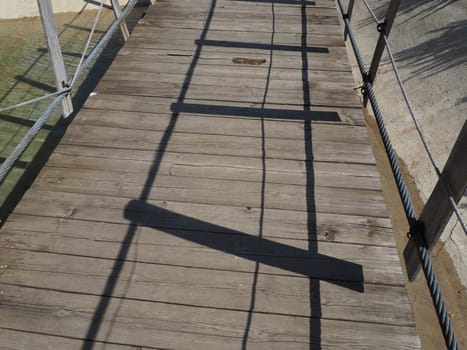 Suspended wooden bridge. Stanisici, Bijelina, Bosnia and Herzegovina. A bridge made of planks and railings, which can be carried by 4 people