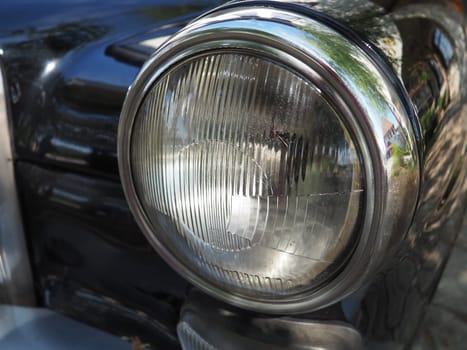 Vintage old headlight of a Mercedes Benz car, pontoon model. Retro car in good condition. Product of the German car industry.