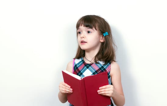 Little girl reading a book at home