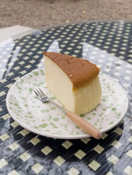 Piece of cheesecake serving in the garden, stock photo