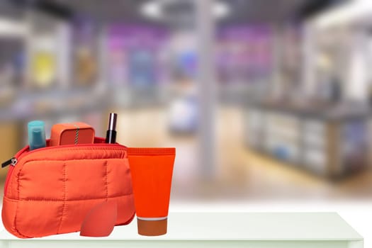 Decorative cosmetics with bag on table over blurred drug store or stylist room. Template for your display product montage. Space.