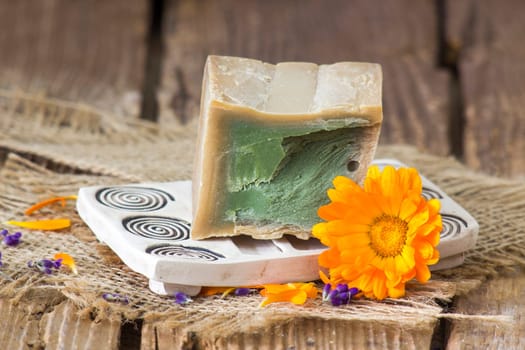 Natural handmade soap with calendula flower on rustic wooden background