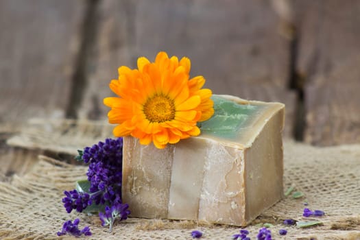 Natural handmade soap with calendula and lavender on old rustic background