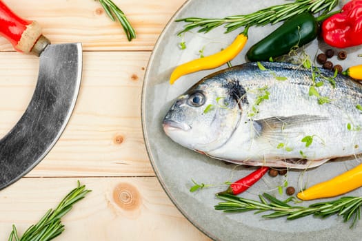 Uncooked dorado fish with ingredients for cooking. Top view