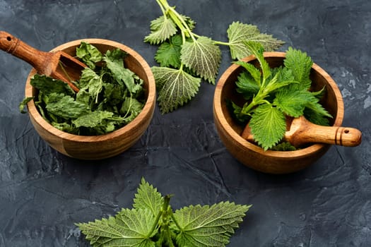 Fresh nettle leaves and pharmacy bottle on the table. Medicinal plant