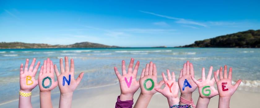 Children Hands Building Colorful French Word Bon Voyage Means Have A Good Trip. Summer Ocean, Sea And Beach As Background