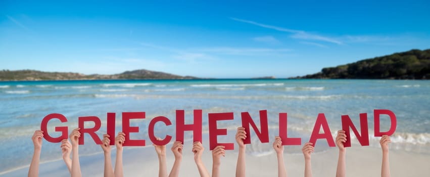 People Or Persons Hands Building German Word Griechenland Means Greece. Summer Ocean, Sea And Beach As Background.
