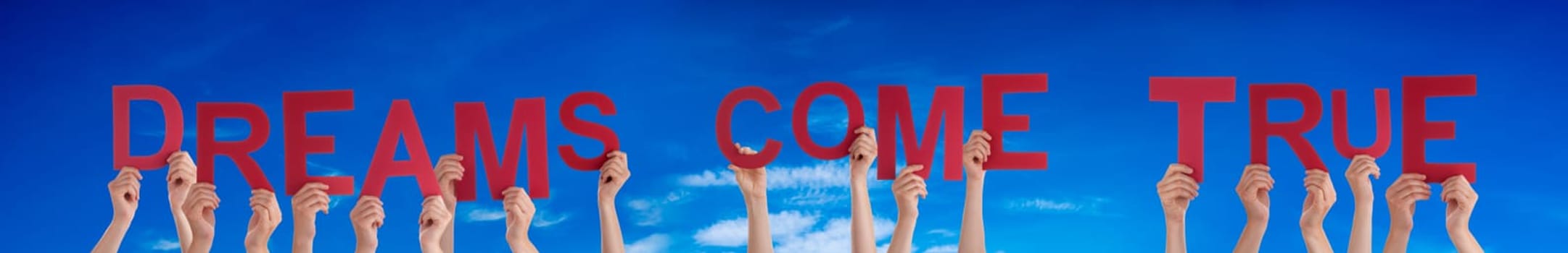 People Or Persons Hands Building English Word Dreams Come True. Summer Ocean, Sea And Beach As Background.