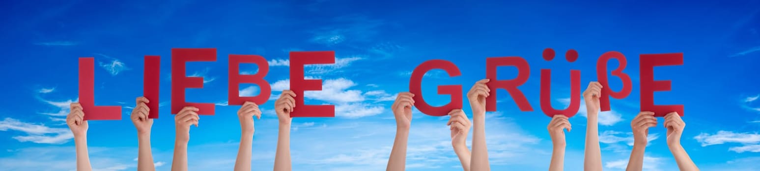 People Or Persons Hands Building German Word Liebe Gruesse Means Many Greetings. Blue Sky As Background.