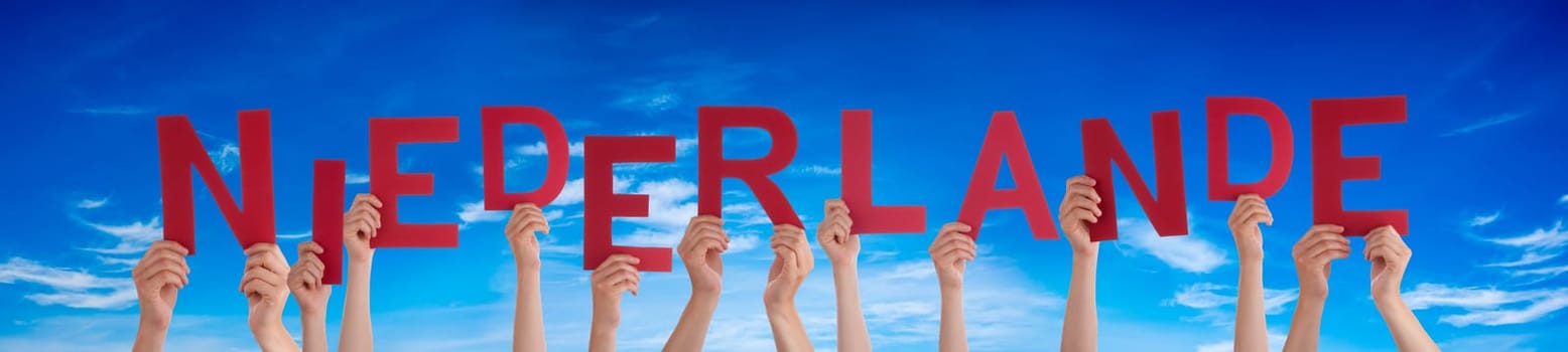 People Or Persons Hands Building German Word Niederlande Means Netherlands. Blue Sky As Background.