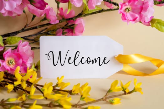 Spring Flower Arrangement With White Label With English Text Welcome. Colorful Flower Branch Decoration With Yellow And Purple Blossoms.