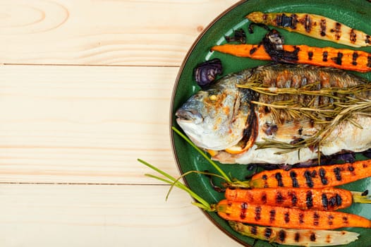Barbecue whole dorado fish or sea bream with grilled vegetables. BBQ fish