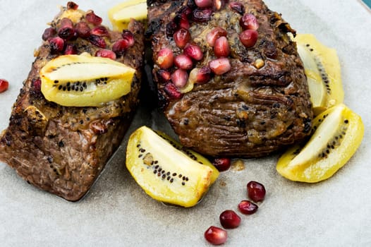 Cooked veal meat in kiwi and pomegranate sauce.