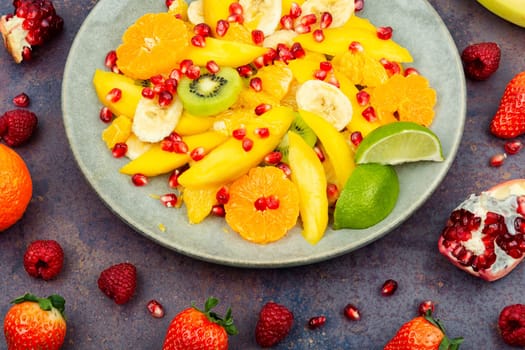 Fresh salad of mango, citrus, banana and ripe berries. Top view