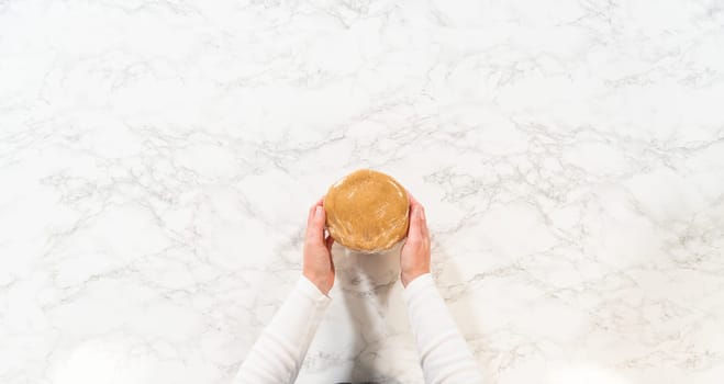 Top view of a portion of Amber Gingerbread Cookie Dough separated on a marble surface, preparing for further shaping or chilling. The dough is pliable and ready for shaping into cookies or storage for later use.