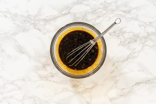 Molasses and eggs combined in a bowl for the Chocolate Gingerbread Cookie Dough recipe. The molasses adds a deep, rich sweetness, perfect for creating a festive holiday cookie.
