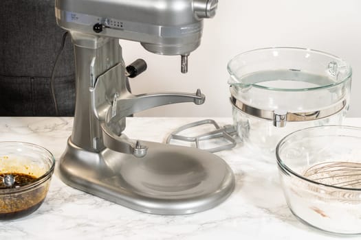 A stand mixer with softened butter and brown sugar in the bowl, ready to be creamed together for the Zesty Orange Gingerbread Cookie Dough recipe. Mixing these ingredients adds a soft texture and sweetness to the dough.
