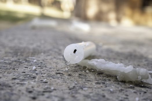 Detail of old white wax candle spent and thrown away
