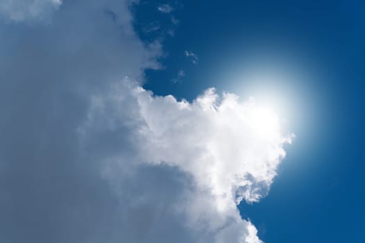 big white cloud with the sun in the background on a summer day